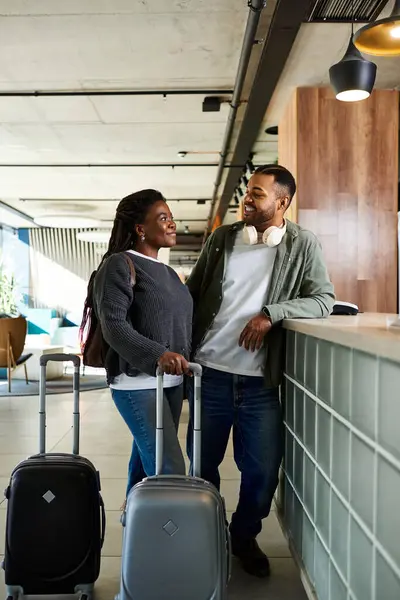 A joyful couple stands at the hotel lobby, preparing for their exciting vacation adventure ahead. — Stock Photo