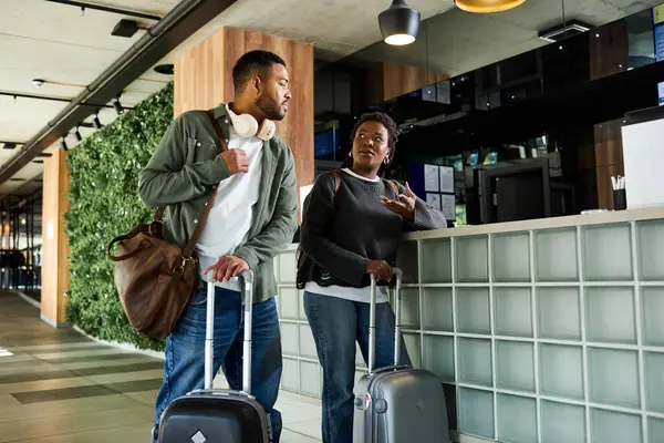 A young African American couple engages with hotel staff, excited to begin their vacation adventure. — Stock Photo