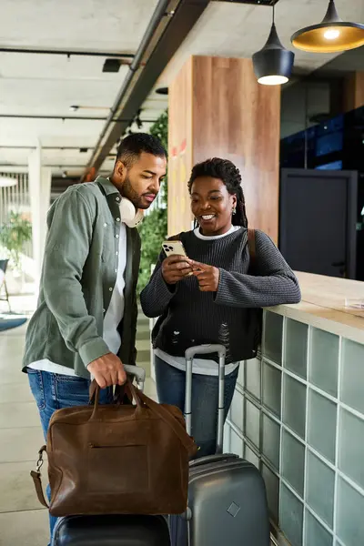 A young couple excitedly discusses their vacation plans while in a trendy hotel lobby, filled with anticipation. — Stock Photo