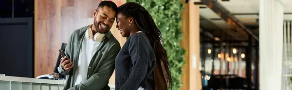 Ein fröhliches junges afroamerikanisches Paar genießt die gemeinsame Zeit in einer gemütlichen Hotellobby. — Stockfoto