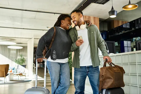 Um casal feliz compartilha um momento em um lobby do hotel, cercado por sua bagagem, pronto para aventuras de férias. — Fotografia de Stock