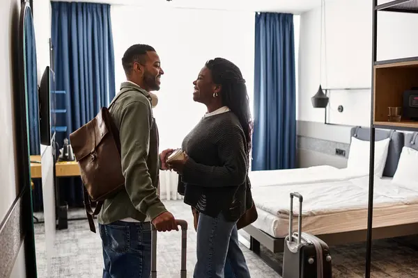 A couple shares joyful moments in a stylish hotel room, celebrating their love and vacation getaway. — Stock Photo