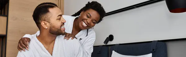 A young African American couple shares a moment of laughter and love during their vacation in a hotel. — Stock Photo