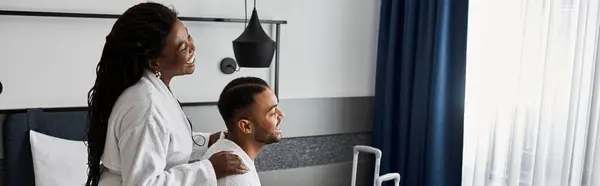 Una giovane coppia gioiosa condivide momenti affettuosi in un'accogliente camera d'albergo durante la loro vacanza. — Foto stock