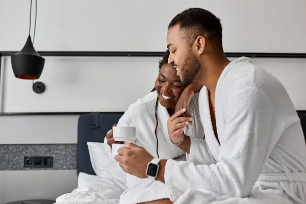 A young African American couple share smiles and laughter while enjoying coffee together on vacation. — Stock Photo