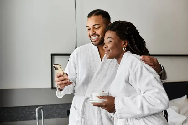A young couple enjoys a delightful moment together, sharing laughter and love in a hotel room. — Stock Photo