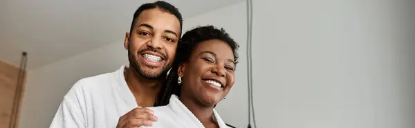 A joyful young couple smiles broadly in their hotel room, celebrating love during a vacation. — Stock Photo