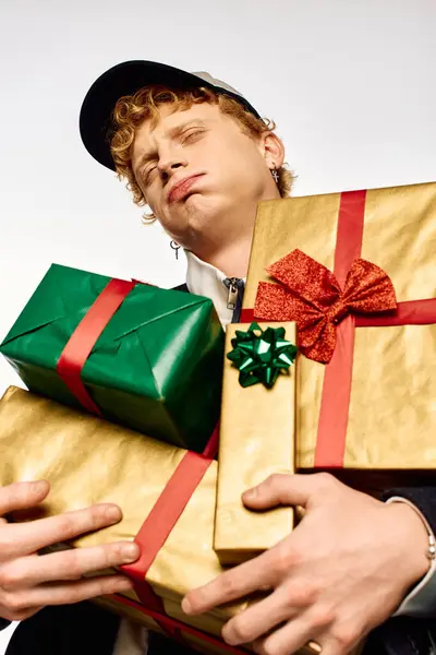 A man showcases his holiday fashion while proudly holding colorful wrapped gifts. — Stock Photo