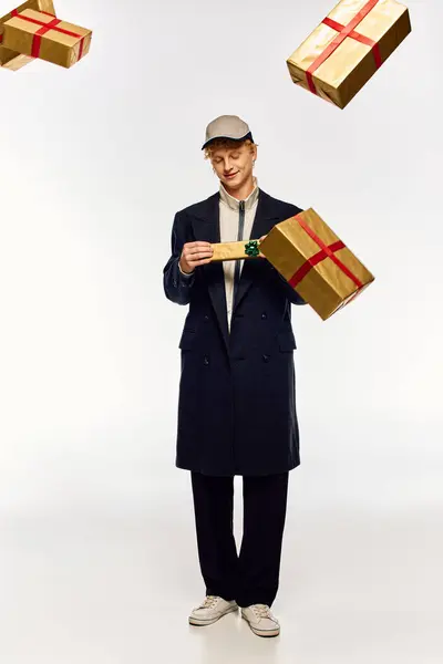 A man in trendy holiday attire stands confidently amidst floating Christmas presents. His outfit embodies modern festive fashion, radiating joy and excitement for the celebration. — Stock Photo