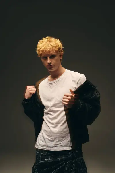 A young man models contemporary holiday fashion with a stylish edge. His striking look features a casual outfit that captures the essence of Christmas 2025 celebrations, embracing modern aesthetics. — Stock Photo