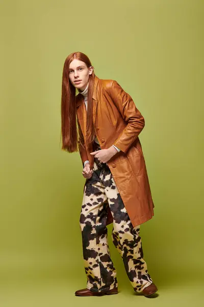Emotional young man with long red hair showcasing unique style in a striking setting. — Stock Photo