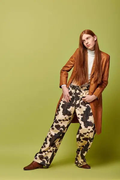Young man expresses emotions while modeling bold clothing in a playful, colorful setting. — Stock Photo