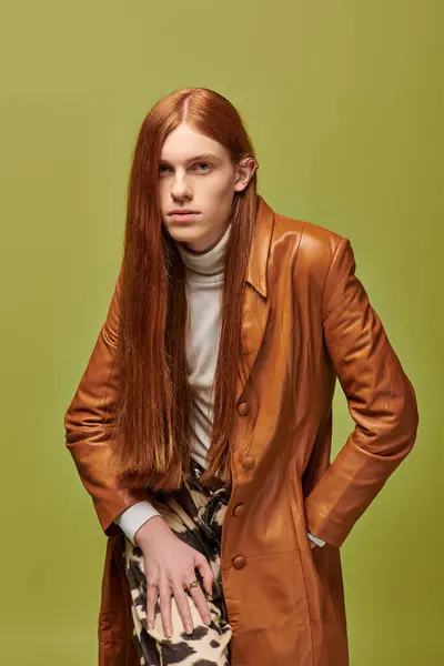 A young man with long red hair wears a striking outfit, conveying deep emotions and introspection. — Stock Photo