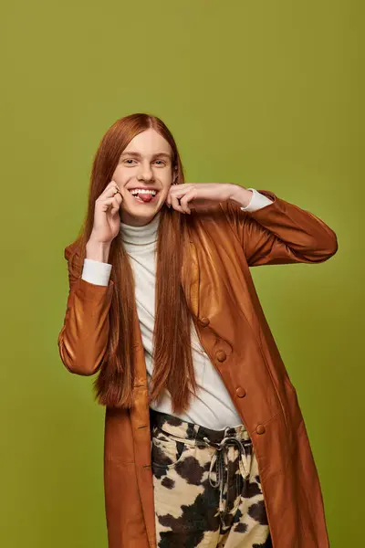 Joven juguetón con el pelo largo y rojo muestra su vibrante personalidad y estilo. - foto de stock