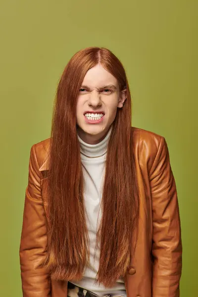 Young man with long red hair shows strong emotions while dressed in a stylish leather outfit. — Stock Photo