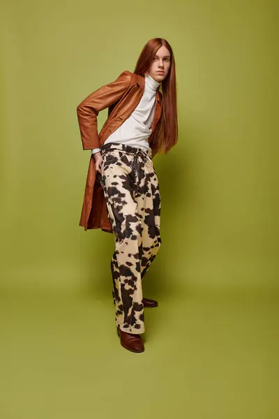 Young man showcases intense emotion while posing in a stylish outfit against a vibrant backdrop. — Stock Photo
