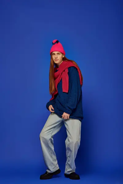A young man with long red hair showcases his emotions in a striking blue setting. — Stock Photo