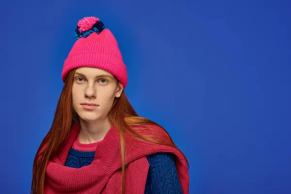 Il giovane mostra emozioni profonde con i suoi lunghi capelli rossi e un sorprendente cappello rosa.. — Foto stock