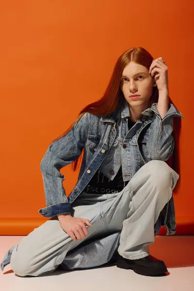 A young man with striking long red hair displays deep emotions while dressed in denim. — Stock Photo