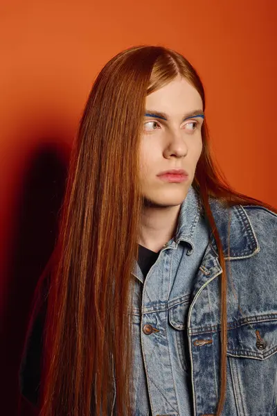A young man with long red hair expresses deep emotions while standing confidently. — Stock Photo