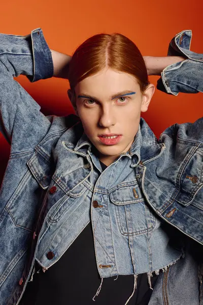 Young man with long red hair expresses deep emotions while stylishly posing in a striking setting. — Stock Photo