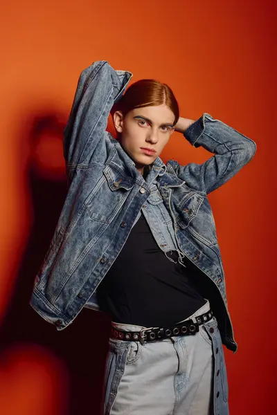 Joven emocional con el pelo rojo largo y llamativo posa con confianza delante de un fondo audaz. — Stock Photo