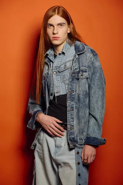 A young man with striking long red hair showcases intense feelings while posing stylishly. — Stock Photo