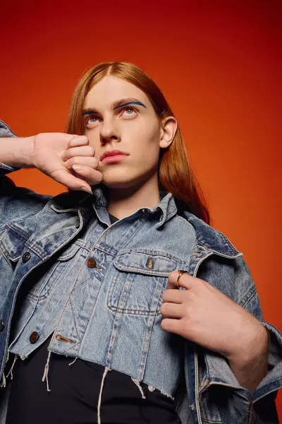 A young man with striking long red hair showcases deep emotions while posing confidently. — Stock Photo