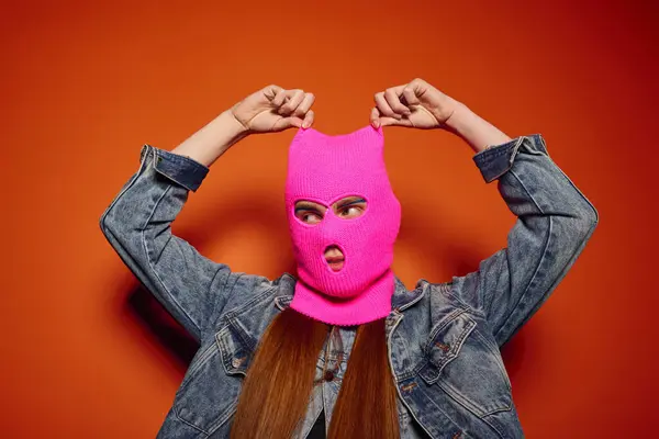 Emotional young man showcases vibrant feelings while wearing a striking pink ski mask. — Stock Photo