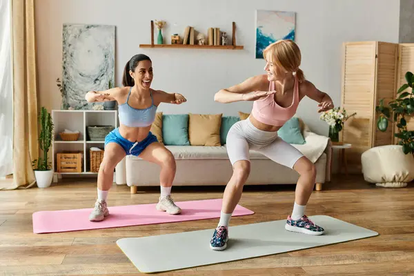Two young women exercise side by side, sharing smiles and encouragement in their cozy space. — Stock Photo