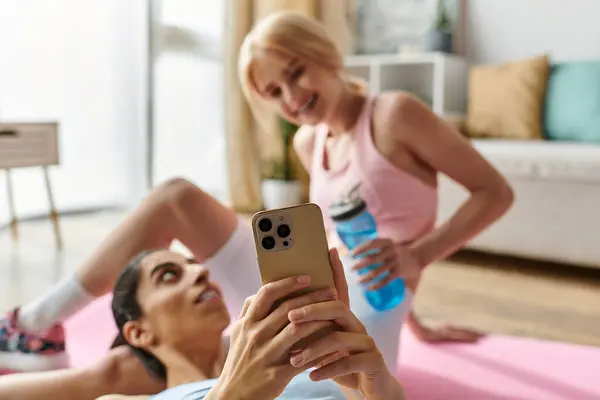 Two young women share a joyful moment during a workout, capturing their love and fun. — Stock Photo