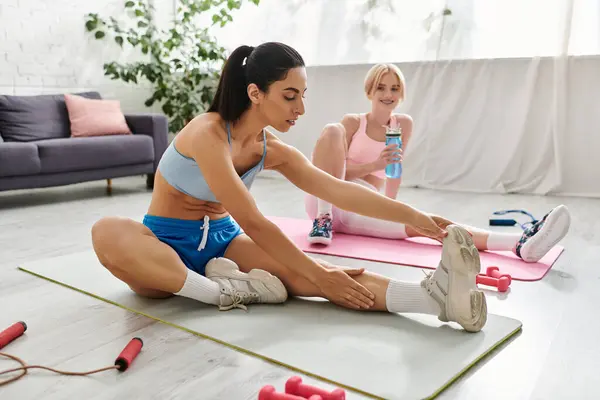 Two young women engage in a loving and supportive workout session in a bright room. — Stock Photo
