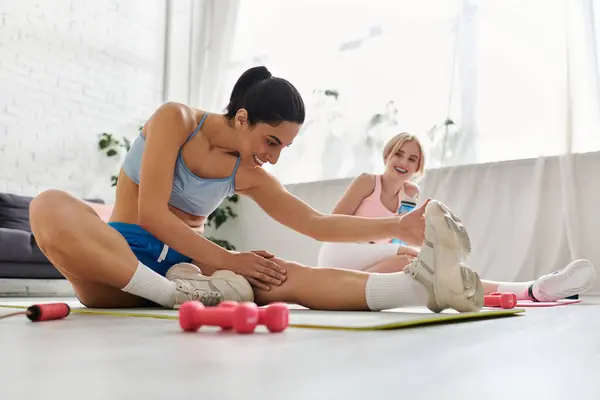 Two women playfully stretch together, showing their love and support for one another. — Stock Photo