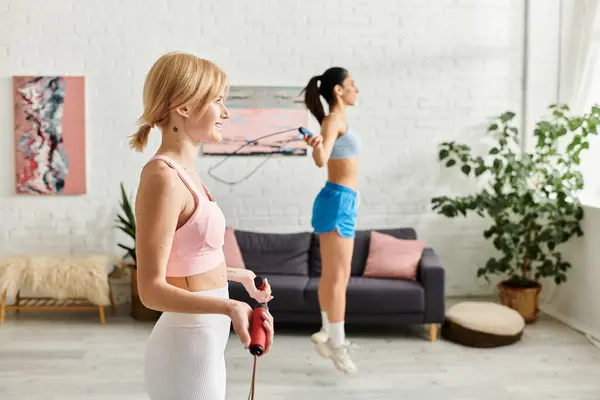 Two young women happily workout together, showcasing their loving connection and fitness journey. — Stock Photo