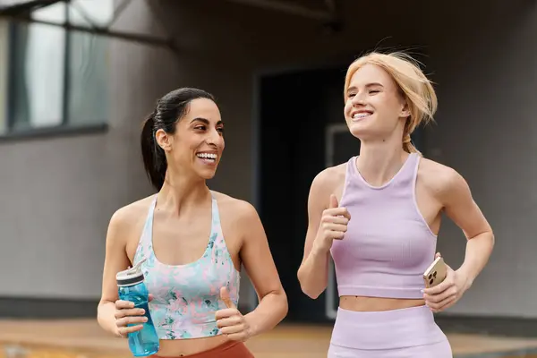 Two young women run happily side by side, laughing and enjoying their time outdoors. — Stock Photo