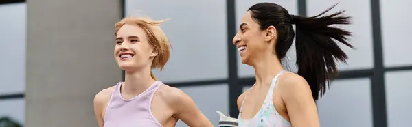 Two young women share laughter while jogging, embracing each others company and joy. — Stock Photo