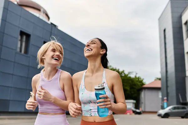 Joyful young couple shares laughter while jogging outdoors in a vibrant city setting. — Stock Photo