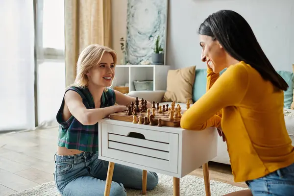 Zwei junge Frauen teilen einen warmen Moment beim gemeinsamen Schachspielen zu Hause. — Stockfoto