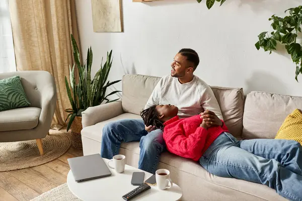 A joyful couple enjoys each others company in their cozy living room, embracing winter vibes. — Stock Photo