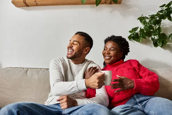 Ein freudiges afroamerikanisches Paar teilt Lachen und Wärme, während es sich drinnen entspannt. — Stock Photo