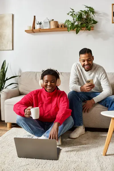 Un couple afro-américain joyeux se détend un jour d'hiver, en utilisant des gadgets — Photo de stock