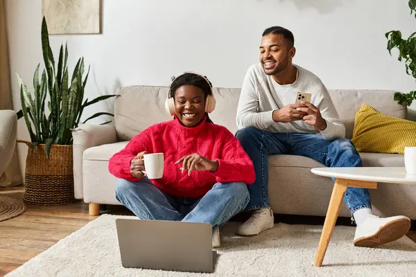 Un couple joyeux profite de leur temps ensemble dans un salon confortable rempli de chaleur et de rire. — Photo de stock