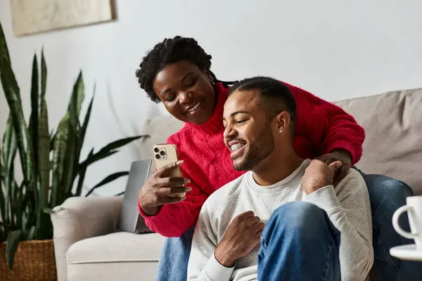 Dois indivíduos felizes desfrutam de tempo de qualidade juntos, sorrindo enquanto usam um smartphone. — Fotografia de Stock