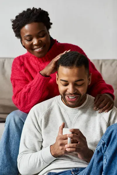 Un couple joyeux profite de l'autre compagnie tout en se relaxant ensemble dans leur salon confortable. — Photo de stock