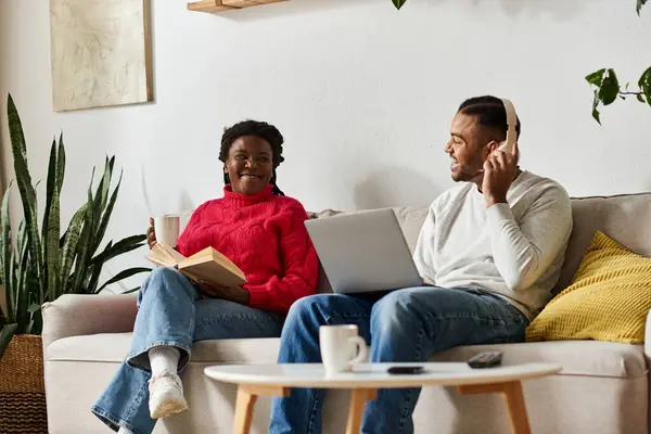 A happy couple enjoys each others company while relaxing at home in cozy sweaters. — Stock Photo