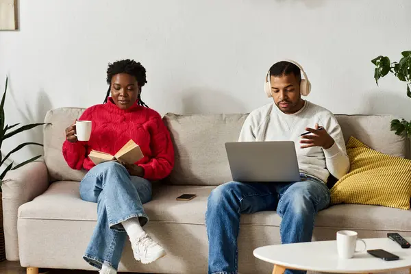 Un couple heureux profite d'un après-midi d'hiver confortable, lisant et travaillant ensemble dans leur salon. — Photo de stock