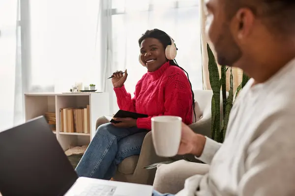 A happy couple enjoys quality time together, laughing and relaxing in their cozy living room. — Stock Photo
