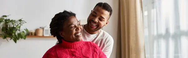 Um casal compartilha risos e calor juntos, desfrutando de momentos aconchegantes em sua sala de estar. — Fotografia de Stock