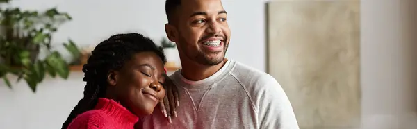 Um casal feliz em camisolas aconchegantes desfruta de tempo de qualidade juntos em sua casa durante o inverno. — Fotografia de Stock