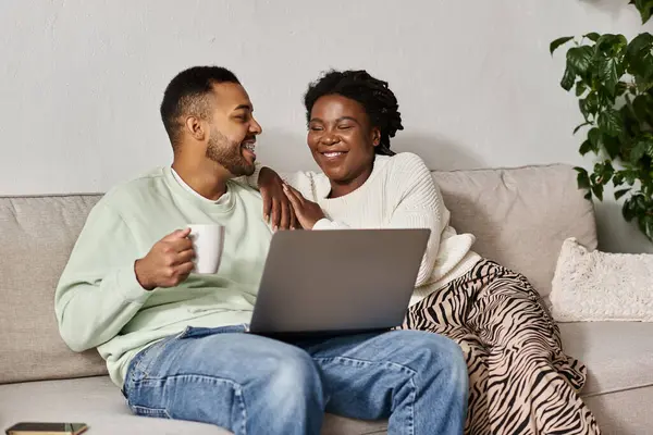 A happy couple enjoys quality time together indoors in cozy sweaters, smiling and relaxing. — Stock Photo